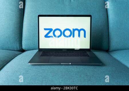 Laptop mit Logo der Zoom Cloud Meetings-App. Arbeiten und Treffen von zu Hause aus. Stockfoto