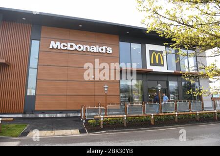 Von außen ein typisches McDonalds Restaurant in Großbritannien ohne Leute auf dem Bild. Das Bild zeigt die Außenseite eines Gebäudes mit Drive-Thru. Stockfoto
