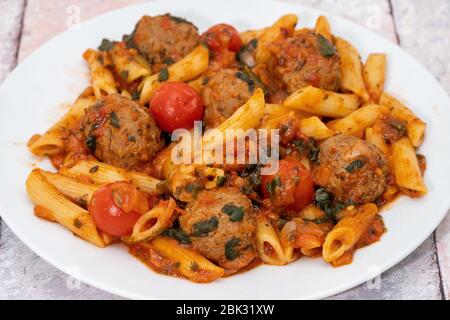 Penne mit Fleischbällchen in Tomatensauce Stockfoto