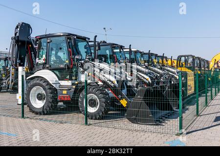 Viele verschiedene Traktoren stehen in Reihe auf der Landwirtschaftsmesse zum Verkauf im Freien. Ausrüstung für die Landwirtschaft. Stockfoto
