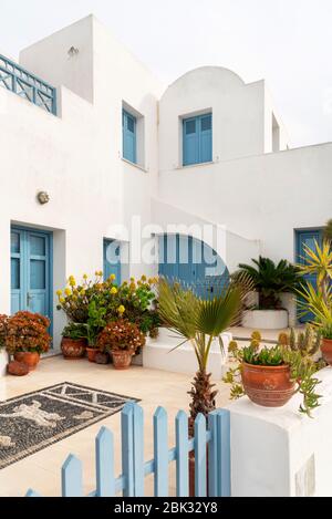 Weißes Haus mit blauen Fenstern und Türen in Santorini, Griechenland Stockfoto