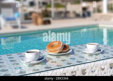 Donuts und Kaffee, die nicht für das Frühstück am Pool Stockfoto