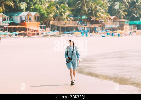 Canacona, Goa, Indien. Junge Kaukasische Dame Frau Mit Kamera Zu Fuß Entlang Seashore Auf Palolem Beach Im Sommer Sonnigen Tag. Stockfoto