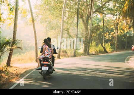 Margao, Goa, Indien - 16. Februar 2020: Menschen Fahren Auf Motorroller Motorrad Auf Der Straße In Sunny Light. Stockfoto