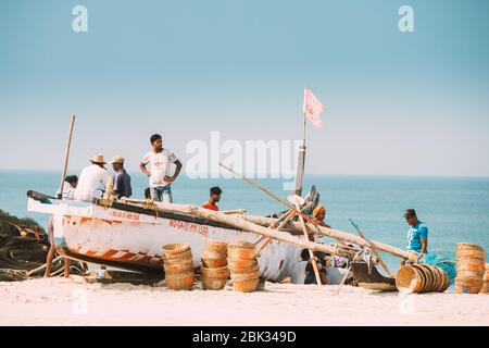 Arossim, Goa, Indien - 18. Februar 2020: Fischer, Die In Der Nähe Von Pulled Boat Aus Dem Meer Ruhen Stockfoto