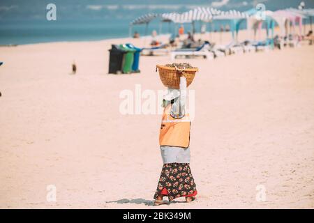 Arossim, Goa, Indien - 18. Februar 2020: Frau Sammelt Müll Am Strand In Sunny Day. Frau, Die Müllkorb Auf Ihrem Kopf Trägt Stockfoto