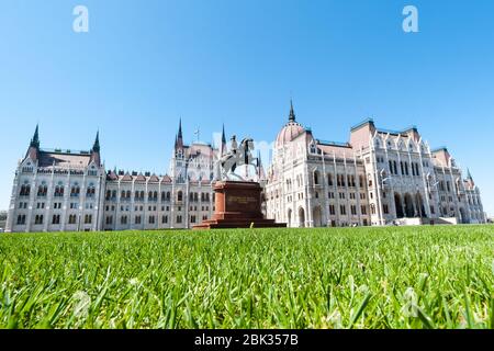 BUDAPEST, UNGARN - 20. APRIL 2020: Denkmal für Franz II. Rakoczi mit dem ungarischen Parlamentsgebäude, auf dem Lajos Kossuth Platz in Budapest. Stockfoto