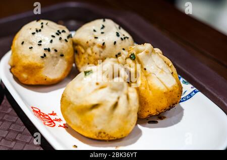 Eine gemischte Platte mit Shengjianbao (2 Schweinefleisch und 2 Schweinefleisch und Garnelen) Da Hu Chun Restaurant Sichuan Zhonglu in Shanghai Stockfoto