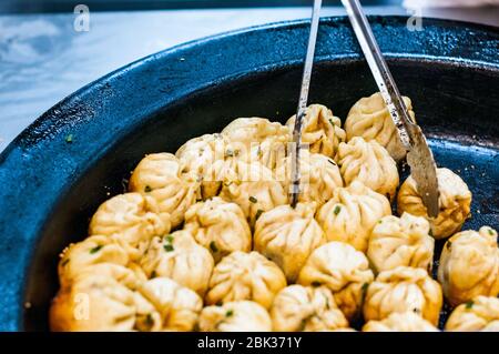 Shengjianbao in der schweren eisernen Kochen Pfanne warten Esser Da Hu Chun Restaurant in Shanghai. Stockfoto