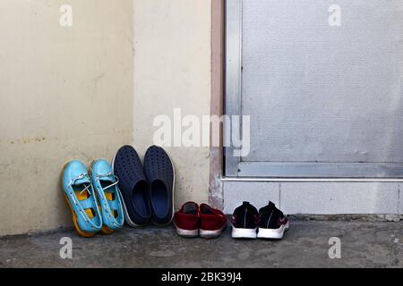 Foto von Schuhen und Pantoffeln an der Tür eines Hauses. Stockfoto