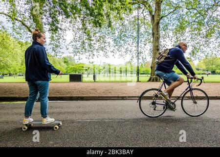 London, Großbritannien. Mai 2020. Eine ungewöhnliche Art zu trainieren, ein Skateboarder wird von einem Radfahrer geschleppt - Battersea Park ist viel ruhiger, da das Wetter kühler ist und mit ziemlich schweren Duschen gemischt. Die "Lockdown" geht weiter für den Ausbruch des Coronavirus (Covid 19) in London. Kredit: Guy Bell/Alamy Live News Stockfoto