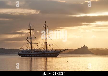 Tall Ship ankerte in Mounts Bay Cornwall an einem ruhigen ruhigen ruhigen Morgen mit St. Michael's Mount über die Bucht Stockfoto