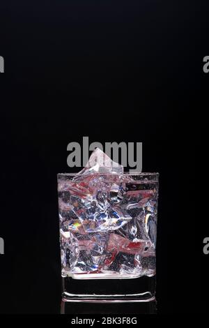 Tumbler glass filled with ice cubes, cool, refreshing drink. Stockfoto