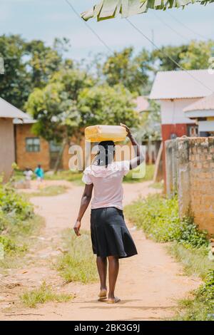 Frau, die Wasser in Entebbe, Uganda, trägt Stockfoto