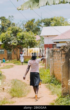 Frau, die Wasser in Entebbe, Uganda, trägt Stockfoto