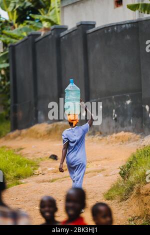 Frau, die Wasser in Entebbe, Uganda, trägt Stockfoto
