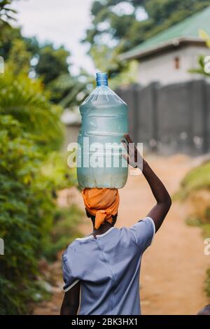 Frau, die Wasser in Entebbe, Uganda, trägt Stockfoto