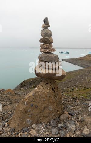 Steinstapel balancieren auf einem großen Felsblock in der Nähe des Gletschersees Jökulsárlón, Südisland. Stockfoto