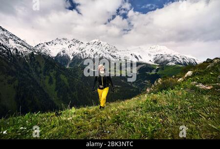 Portrait von Touristen mit grauen Bart und gelbe Hosen in den verschneiten Bergen. Outdoor Travel Concept Stockfoto