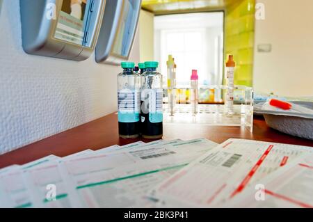 Rack mit Blutgefäßen mit Barcode-Etiketten zur korrekten Identifizierung von verschiedenen Patienten. Tablett mit Röhrchen mit Blutproben, Spritze und Labor Stockfoto