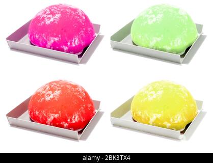 Ein Satz von vier bunten Mochi isoliert auf weißem Hintergrund. Gelbe Zitronen-Mochi, grüner Tee-Mochi, rote Erdbeer-Mochi, lila Himbeer-Mochi Stockfoto