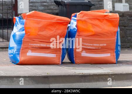 Bristol-April-2020-England- eine Nahaufnahme von zwei hellen Müllsäcken auf dem Bürgersteig warten auf gesammelt zu werden Stockfoto