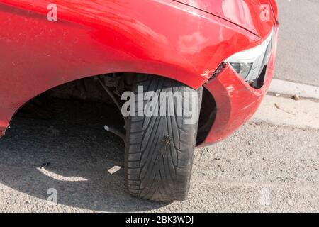 Eine Nahansicht eines Autos, das in einem Unfall war und hat dazu geführt, dass das Vorderrad von der Haupt chasey des Autos abgebrochen wurde, hat das Rad Stockfoto