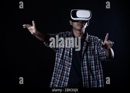 Student Mann trägt Virtual-Reality-Brille im Studio, Smartphone mit VR-Headset. Stockfoto