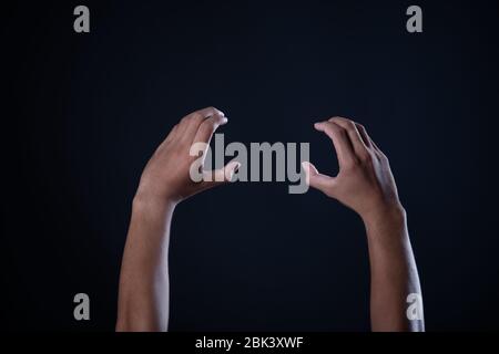 Mann Hand Messung unsichtbare Gegenstände. Isoliert auf Grau Stockfoto