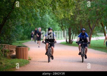 Austin, Texas, USA. April 2020. Die Polizei patrouilliert auf dem Butler-Wanderweg und dem Fahrradweg, da die Bewohner von Austin Ende April mildes Frühlingswetter genießen. Texas bereitet sich darauf vor, die Beschränkungen für den Aufenthalt zu Hause und die Geschäfte vorsichtig zu lockern, als Reaktion auf die Coronavirus-Epidemie ab dem 1. Mai. Der Staat hat fast 700 Todesfälle durch das Virus bis April gesehen. Kredit: Bob Daemmrich/ZUMA Wire/Alamy Live News Stockfoto