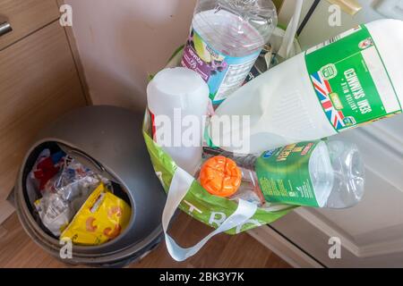 Küchenbehälter für allgemeinen Abfall und Abfall und ein Plastiktragebeutel hing an einem Türgriff für das Recycling von Abfall, der getrennt wurde Stockfoto