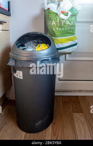 Küchenbehälter für allgemeinen Abfall und Abfall und ein Plastiktragebeutel hing an einem Türgriff für das Recycling von Abfall, der getrennt wurde Stockfoto