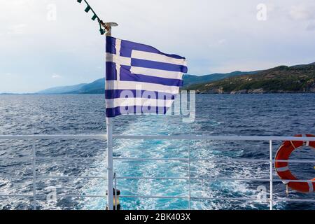 Griechische Flagge auf einem offenen Deck eines Fährschiffes an sonnigen Sommertagen. Griechenland Stockfoto