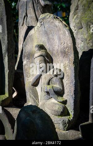 Alte geschnitzte Grabsteine auf dem Friedhof, Tokio, Japan Stockfoto