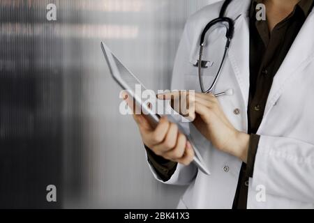 Unbekannter weiblicher Arzt mit Tablet-Computer in der Klinik. Perfekter medizinischer Service im Krankenhaus. Medizinkonzept Stockfoto
