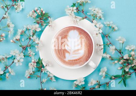 Kaffeetasse mit Latte Art und Frühlingskirschenblüte Stockfoto