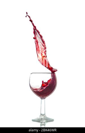 Glas spritzt Rotwein mit weißer Hintergrundfeier Stockfoto