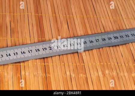 Ein Fragment eines Metalllineals mit einer texturellen Abdeckung. Stockfoto