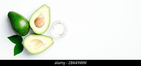 Breites Banner Mockup mit frischen reifen Avocado und ätherischem Öl in Schüssel auf weißem Hintergrund. Flach liegend, Draufsicht. Natürliche Bio-Kosmetik oder gesunde coo Stockfoto