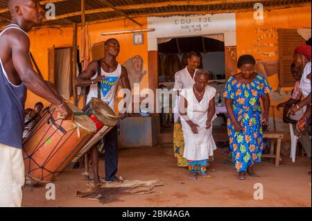 Musiker, die Trommeln spielen, und Frauen tanzen während einer Voodoo- oder Vodu-Zeremonie in Lome, der Hauptstadt von Togo in Westafrika. Stockfoto