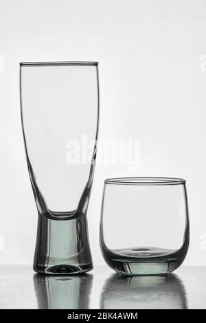 Leere Gläser Bier und Wasser mit Reflektion auf dem Tisch und weißem Hintergrund Stockfoto