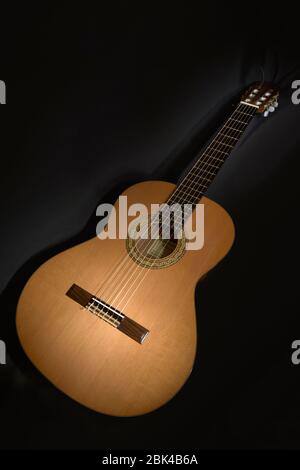 Sechsaitige spanische Gitarre auf schwarzem Hintergrund Stockfoto