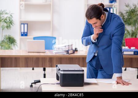 Junge Mitarbeiter von Kopien beim Kopieren von Maschine Stockfoto