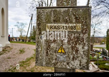 Alte und schmutzige elektrische Box hängt an der Stange Stockfoto