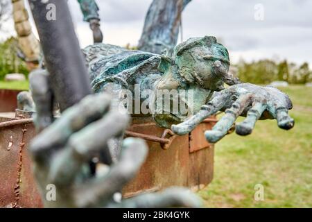 Statue des Menschen, der über den Rand aus Metall schaut Stockfoto