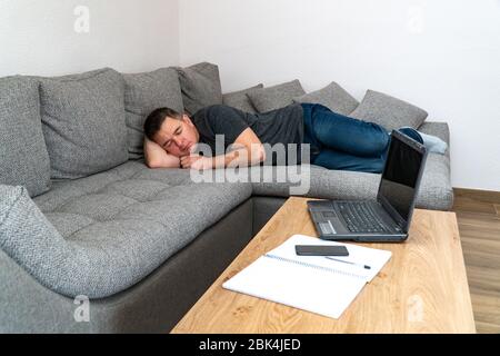 Der Mann ist müde und schläft auf der Couch. Stockfoto
