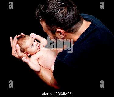 Papa hält sein Neugeborenes. Stockfoto