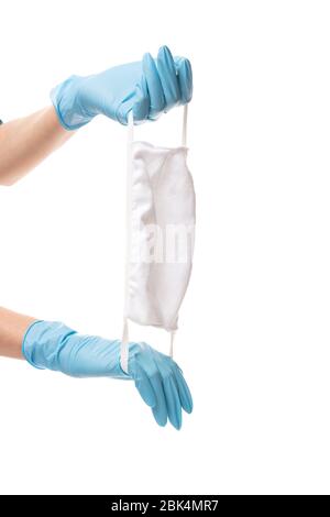 Hände in blauen Handschuhen mit medizinischer Schutzmaske auf weißem Hintergrund Stockfoto