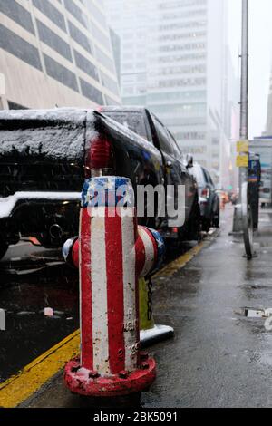 Ein Hydrant, der in den Farben der Flagge der Vereinigten Staaten von Amerika in Manhattan, Midtown New York City/USA lackiert ist Stockfoto