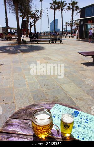 Ein Blick auf den Barceloneta Strand, der beliebteste Strand in Barcelona, Katalonien, Spanien. W Barcelona Hotel (Hotel Vela) in der Ferne gesehen, Bier vor Stockfoto